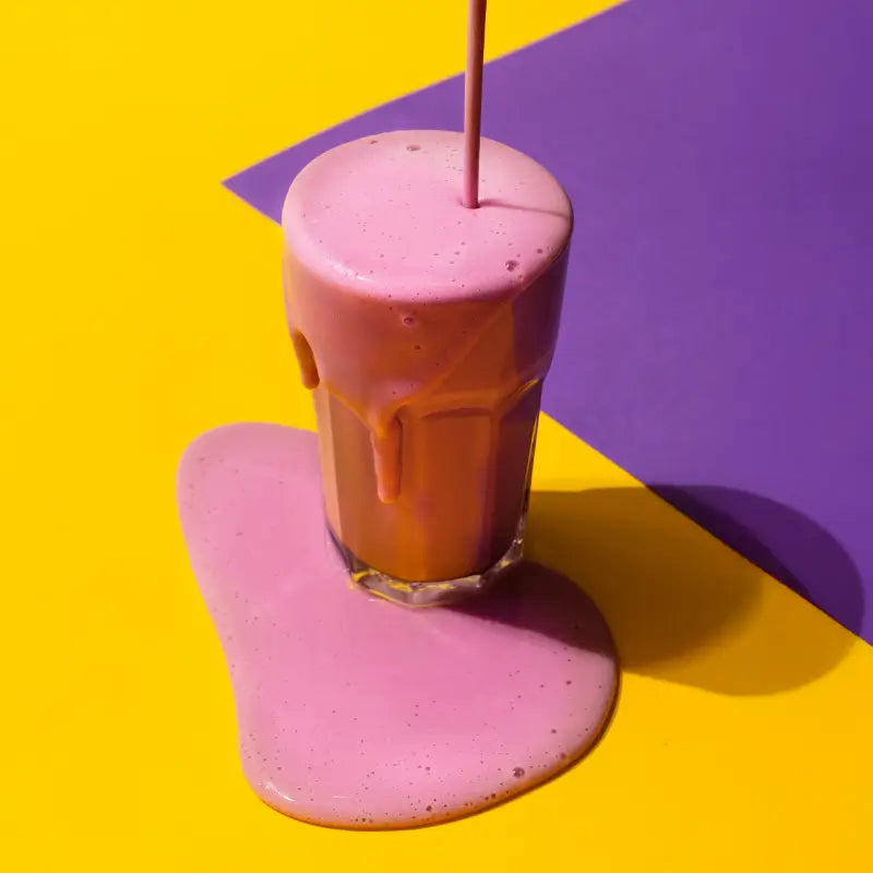 Glass of strawberry flavored vegan protein powder from planet amino